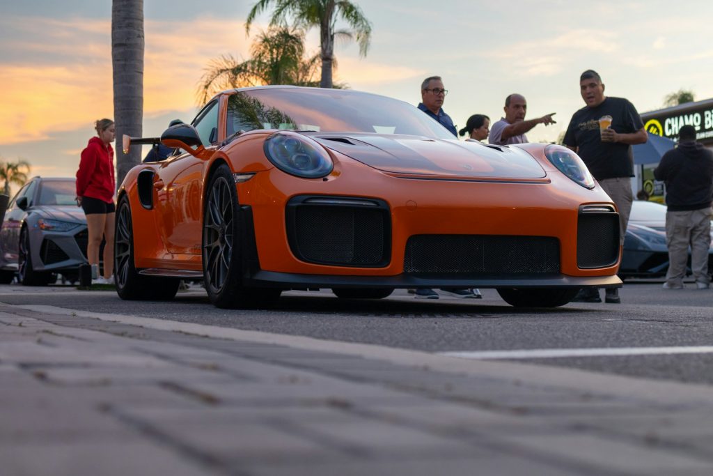 an orange sports car parked on the side of the road